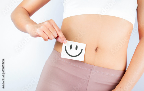 Women Stomach Health. Healthy Female With Beautiful Fit Slim Body  Holding White Card With Happy .Smiley Face In Hands Good Digestion Concepts. High Resolution photo