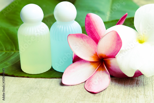 Soft focus  spa equipment and beautiful plumeria flowers resting on natural green leaves.