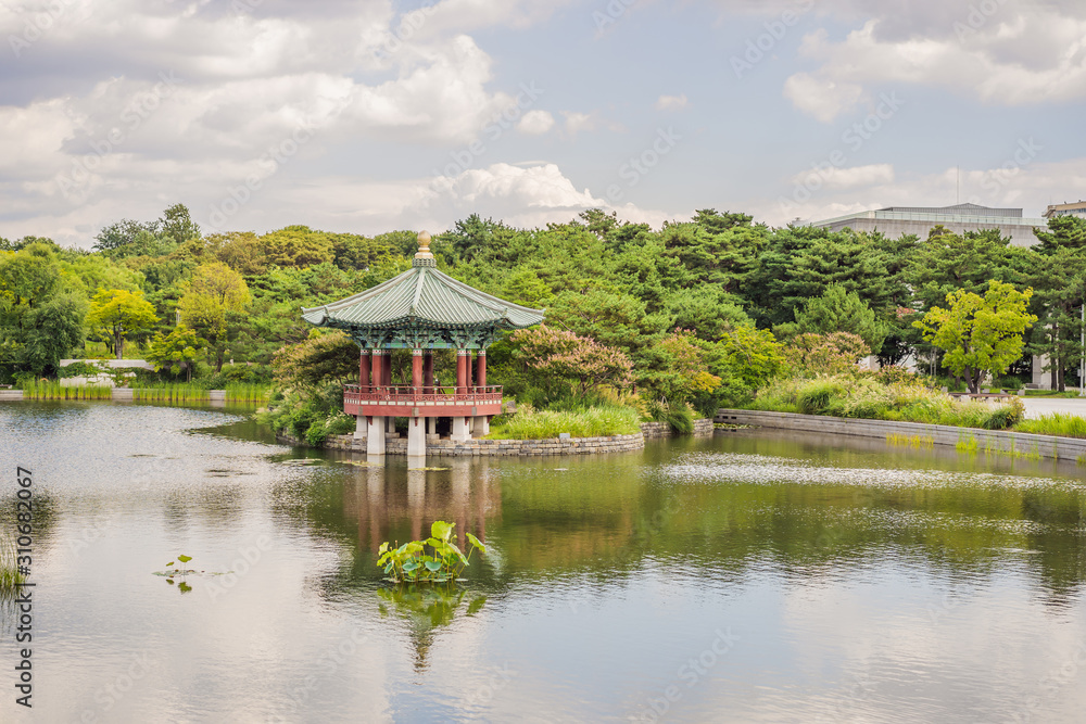 Wooden Korean gazebo in summer park in fishing pond - relax and unwind Wooden Korean gazebo in summer park in fishing pond - relax and unwind