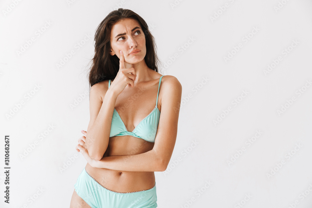 Fototapeta premium Beautiful young slim girl wearing bikini standing isolated