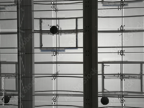 Ceiling of industrial building with metal girders and grid structures. Abstract black and white background photo on the subject of modern architecture, industry or business.
