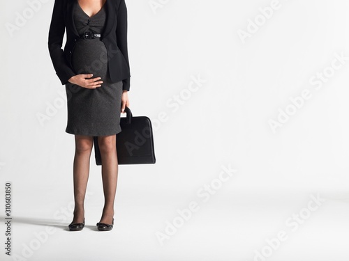 Lowsection Of Pregnant Businesswoman With Briefcase