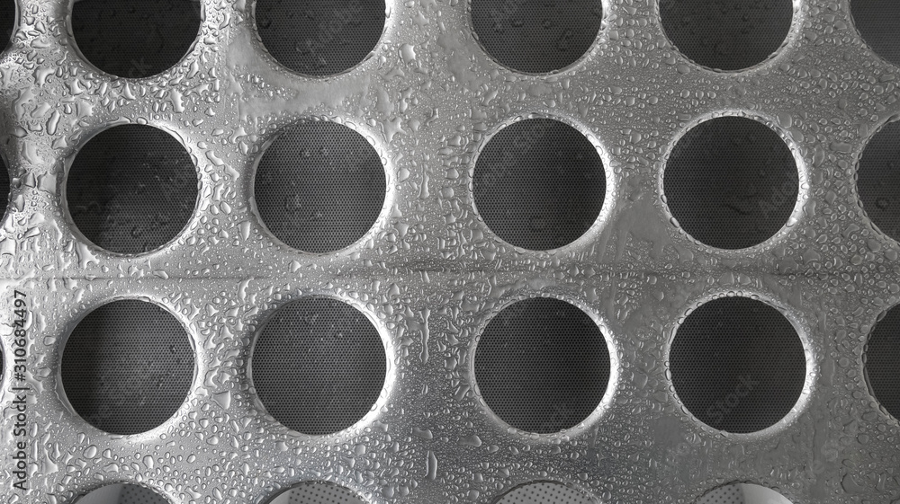 Gray plated metal background made of steel sheet with shiny surface. Large drops of water on the ground. Round holes. Lighting gradient Gray plated metal background made of steel sheet with shiny surface. Large drops of water on the ground. Round holes. Lighting gradient