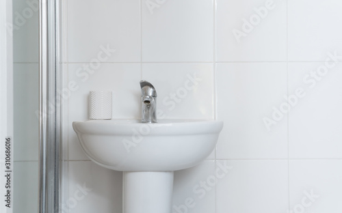 White wash basin in the white bathroom in classic and standard decoration.