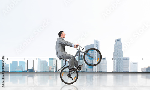 Fototapeta Naklejka Na Ścianę i Meble -  Man riding bicycle on penthouse balcony