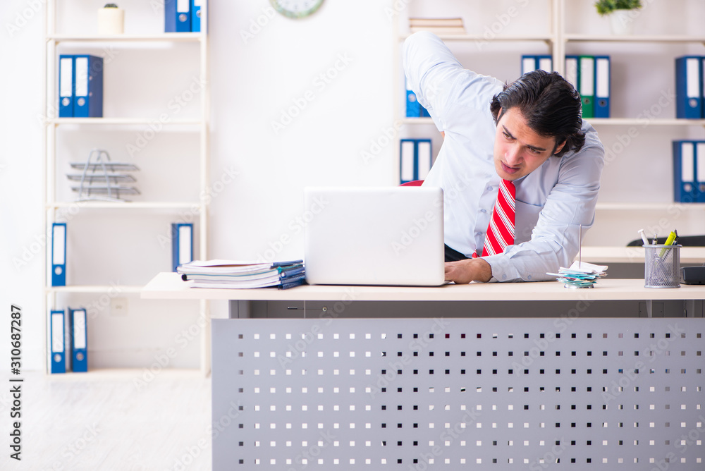 Young male employee suffering in the office Young male employee suffering in the office