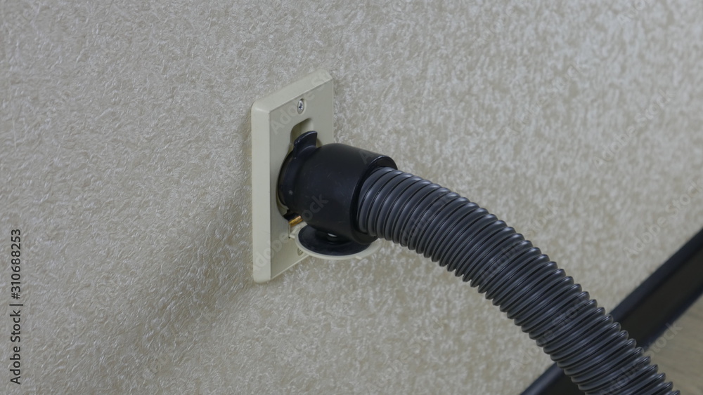 Central vacuum cleaner hose connected to the wall Central vacuum cleaner hose connected to the wall