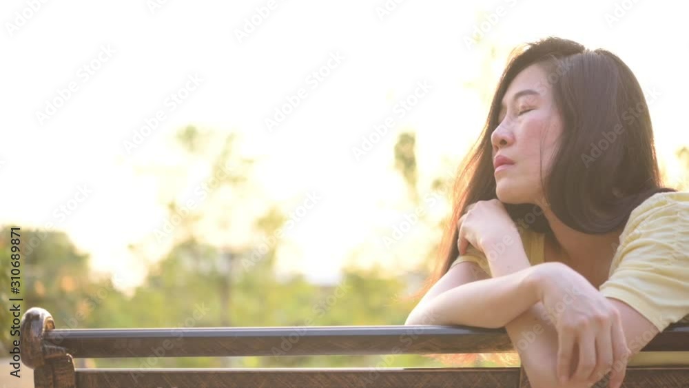 Slow motion,Asian woman sitting alone and depressed,stop abusing domestic violence, health anxiety. Slow motion,Asian woman sitting alone and depressed,stop abusing domestic violence, health anxiety.