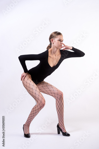 Portrait of a young beauty blondy woman posing in black body, pantyhose and high heels on white isolated background. Stylish girl with an ideal body, model posing training © Виталий Сова