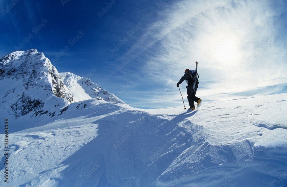 Skier Hiking To Mountain Summit
