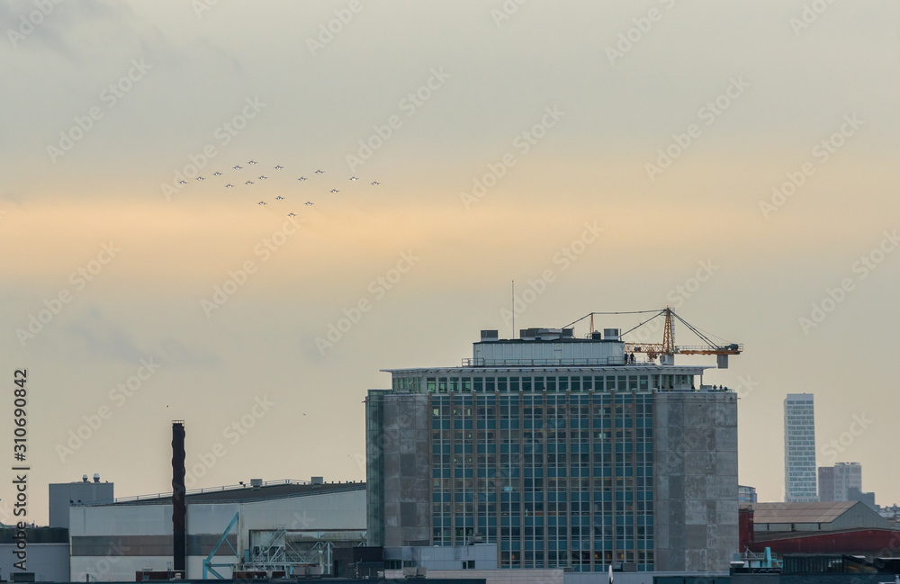 Malmo - Sweden December 16 2019:Swedish fighter jet Saab 39 Gripen or JAS 39A/B/C/D Gripen, flies Christmas tree formation over Malmo port.