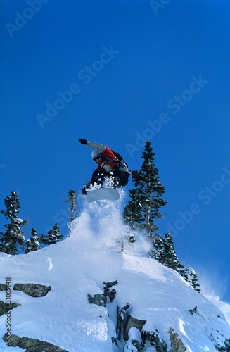 Snowboarder Jumping From Mountain Ledge