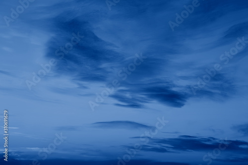 Dark classic royal blue clouds in night evening sky. Natural eco nature background texture with copyspace. Toned with trend popular color of 2020 year blue.