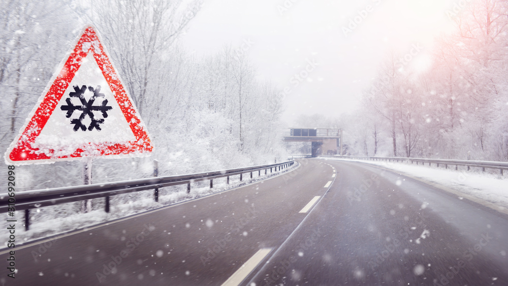 snow and ice warning sign on the highway snow and ice warning sign on the highway