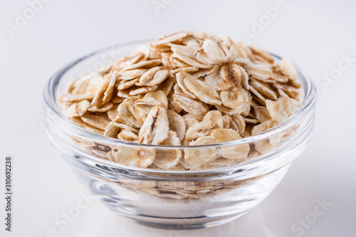 raw oat flakes on white acrylic background