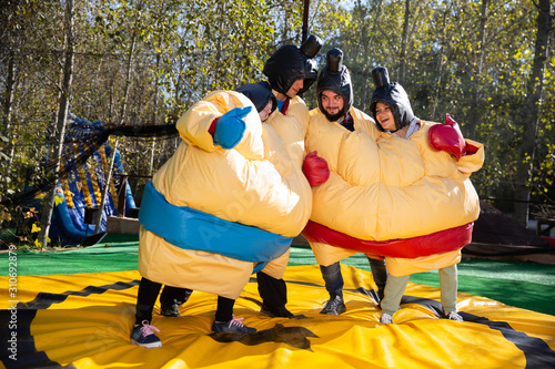 Friends posing in inflatable sumo suits