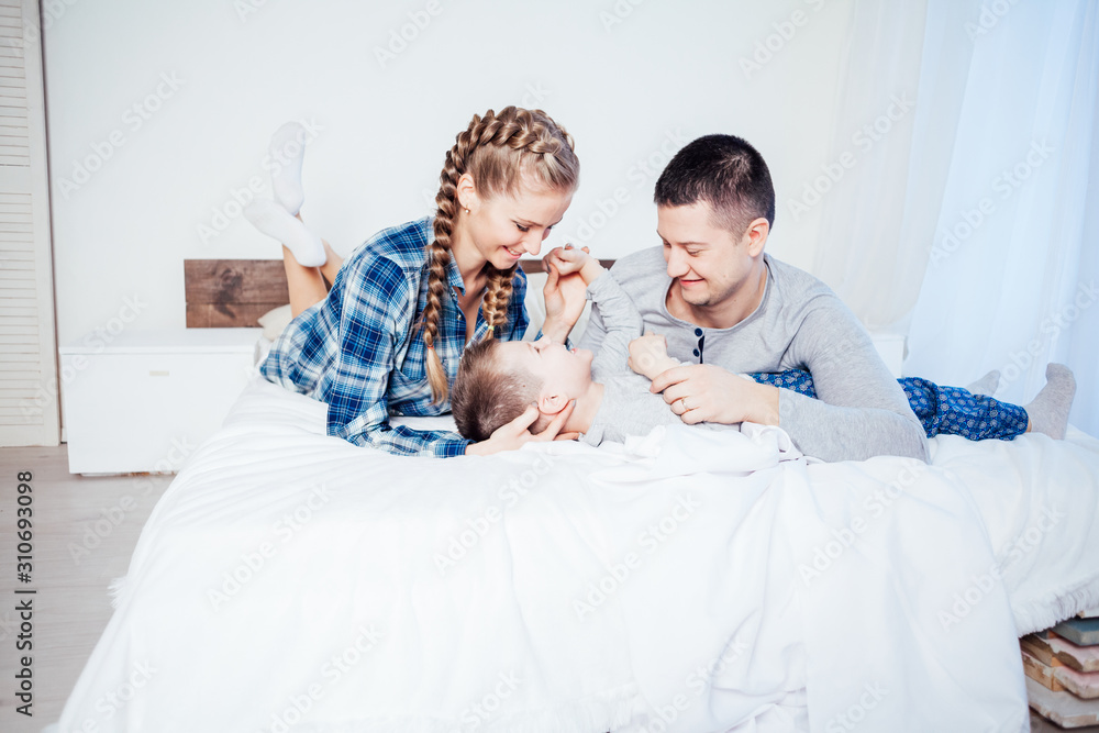 mom dad and young son sleep on the bed in the bedroom mom dad and young son sleep on the bed in the bedroom