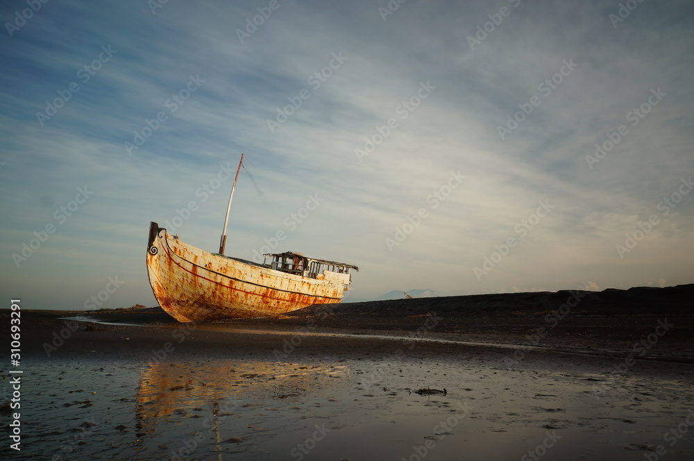 Fototapeta premium Traditional fishing vessels that still use traditional fishing gear, this boat is made of wood that is resistant to sea water. Fishing boats dock at the seashore.