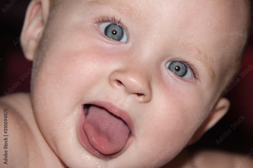 portrait of a baby with blue eyes showing tongue portrait of a baby with blue eyes showing tongue