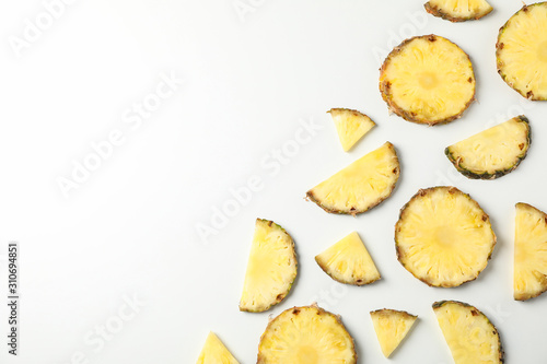 Flat lay with pineapple slices on white background, space for text