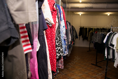 Different clothes: skirts, sweaters, dresses and jackets hang on hangers in the store