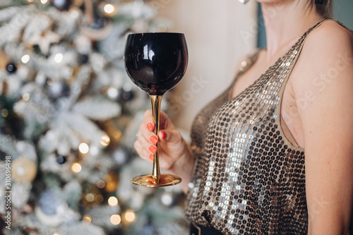 Photography Festive female hand in bright party clothes holding goblet of alcohol beverage close-up