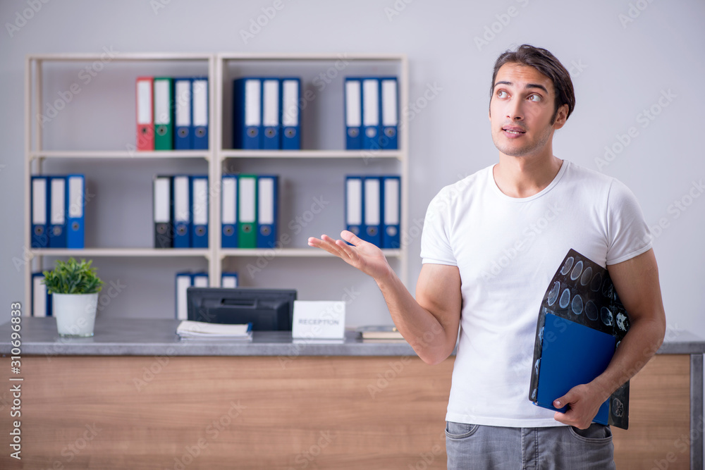 Fototapeta premium Young man at hospital reception desk