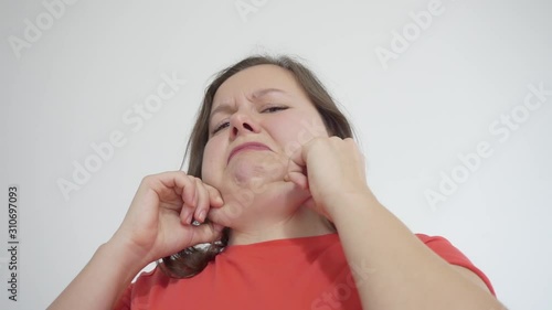 Fatty young woman sees her double chin in the mirror and screams in horror