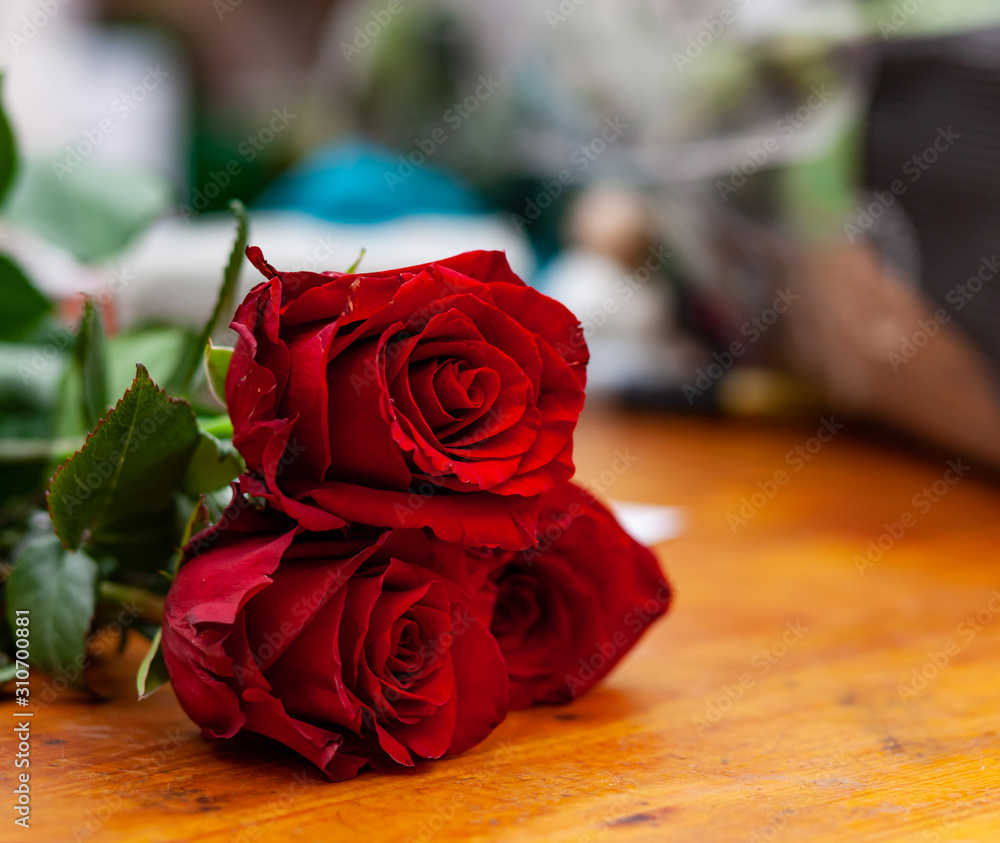 Red roses are on the counter in the flower shop. Red roses are on the counter in the flower shop.