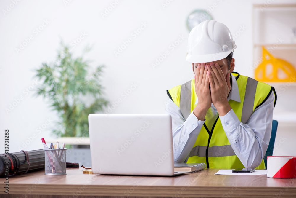 Young male architect working in the office Young male architect working in the office