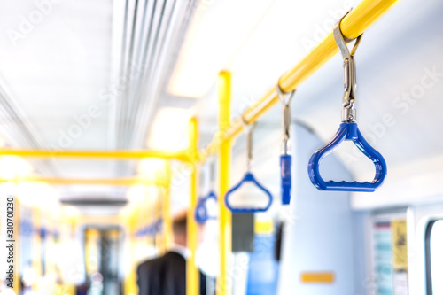 Canvas Print Blue triangles hanging on handrail inside metro carriage