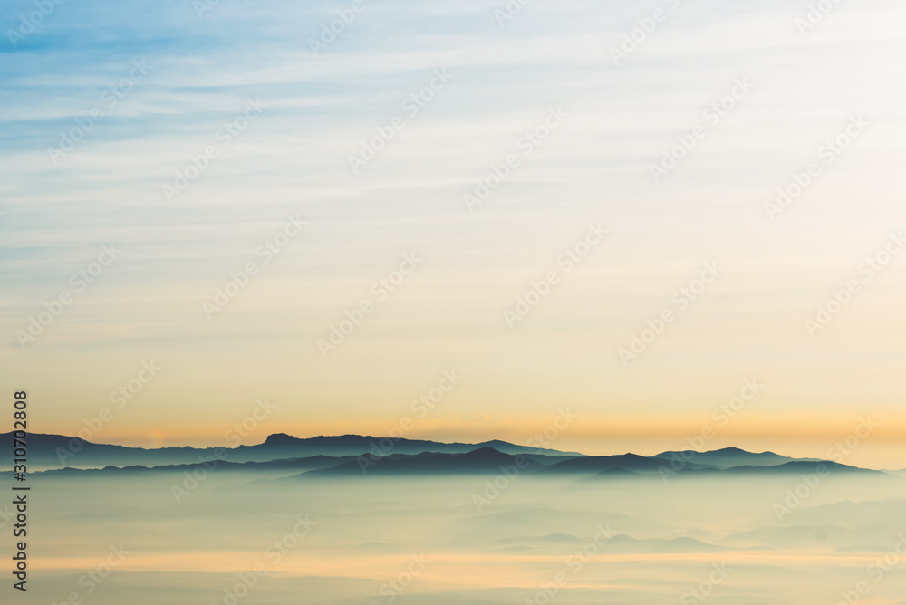 Landscape images of the complex mountains Floated out of the mist in the morning while the sun began to rise from the horizon, beautiful nature background to travel concept.