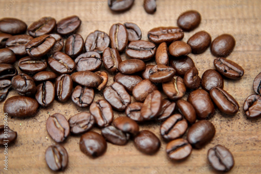 Naklejka premium Kaffebohnen die auf einem Brett ausgeschüttet sind