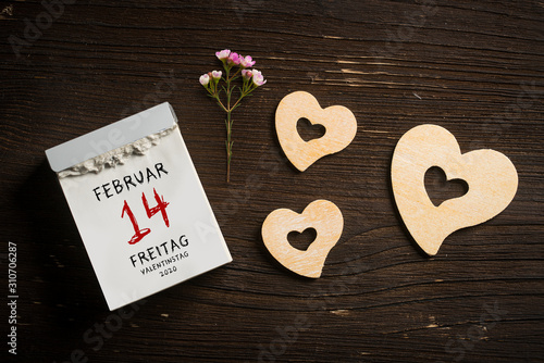 tear-off calendar with Valentine's Day 2020 on top on wooden background