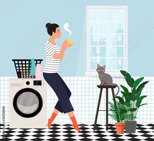 Housewife in the bathroom doing laundry and drinking tea.