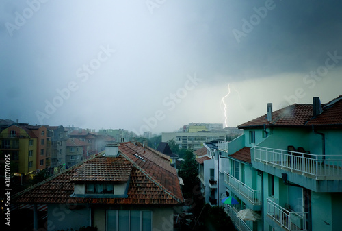 Lightning strike over dark blue sky in night city
