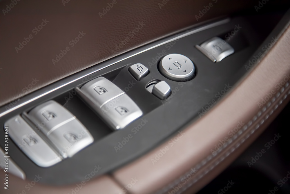 Car brown Leather Interior Details Of Door Handle With Windows and mirrors Control in a new modern premium luxury car. close-up, soft focus Car brown Leather Interior Details Of Door Handle With Windows and mirrors Control in a new modern premium luxury car. close-up, soft focus