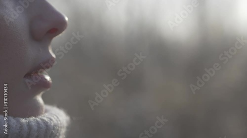 Woman breathing in winter. Portrait of a girl with frosty breath