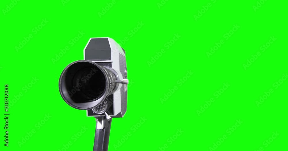 Obsolete fully mechanical film camera moves on a green background Obsolete fully mechanical film camera moves on a green background