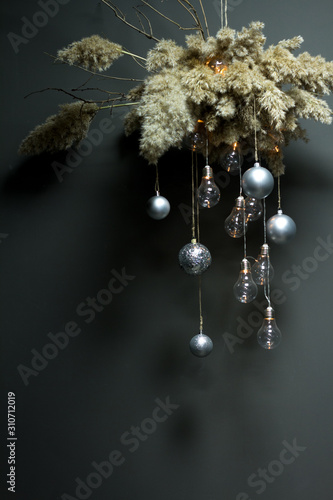 A decorative reed cloud hanging from above with a Christmas decor and a garland of light bulbs, Christmas or New Year concept