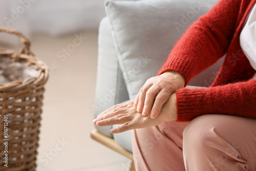 Senior woman suffering from pain in wrist at home