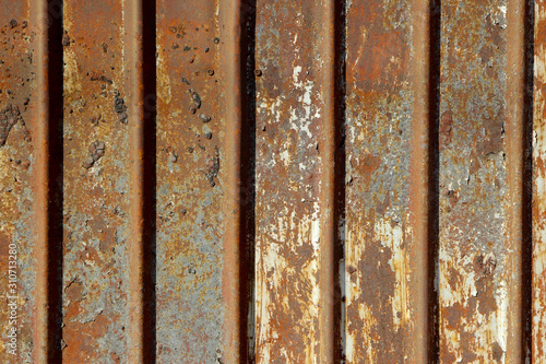 Texture of an old, dirty and totally rusted metal fence once covered with white paint