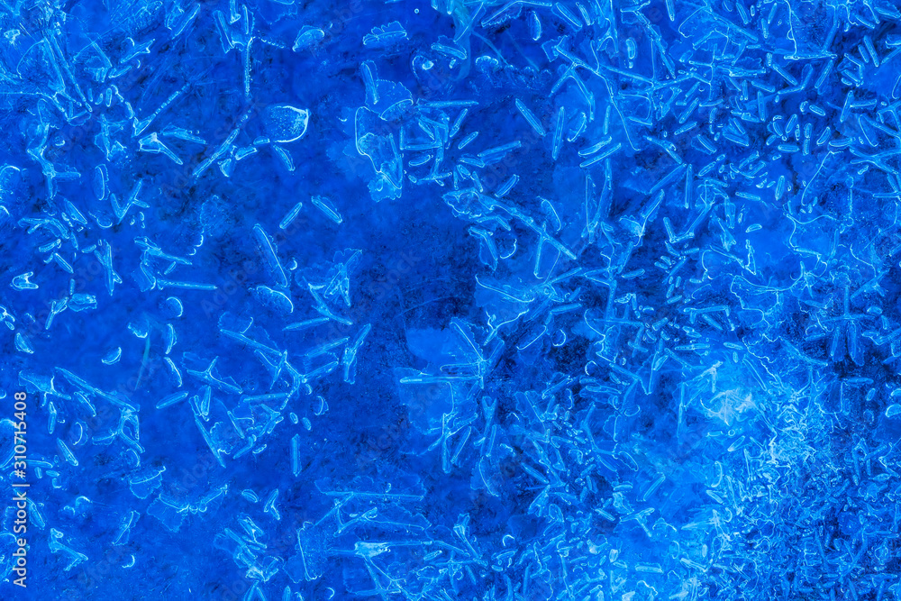 blue texture of an ice surface with pure azure water ,cold snow cryslallized wall background ,winter frozen lake side close up , abstract macro wallpaper