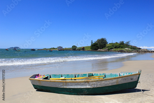 Solitary wooden fishing boat at sea beach with beautiful sky