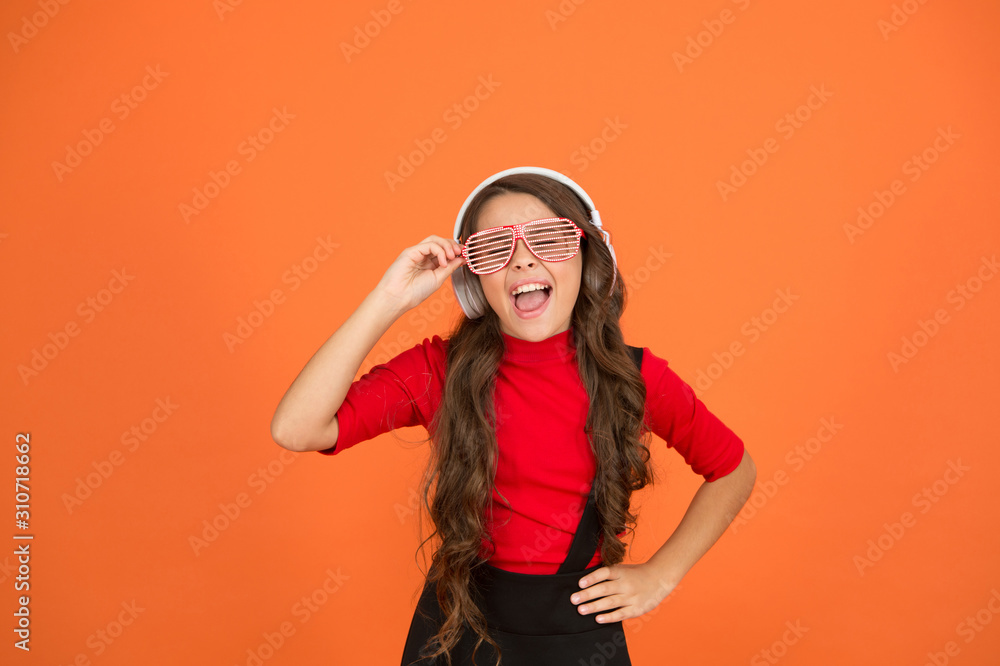 using wireless headset for DJ disco. small happy girl listen music in headphones. funny child in party glasses. time having fun. modern kid enjoy music. feeling stylish and confident. school radio dj