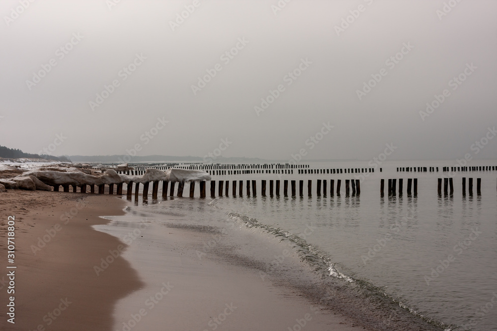 Wooden breakwaters at the beach in winter
