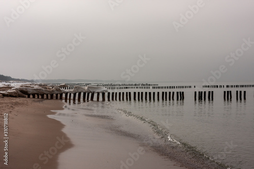 Wooden breakwaters at the beach in winter © Vladis