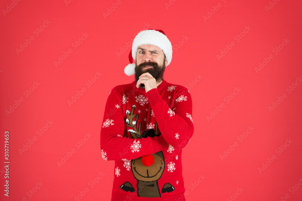 happy new year. cheerful hipster funny knitted sweater. warm clothes in cold winter weather. holiday season mood. bearded man santa hat red background. merry christmas. ready for xmas party