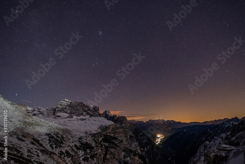 Night winter sky looking over Auronzo di Cadore village from Tre Cime mountains
