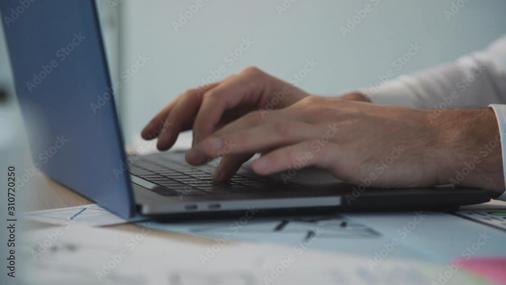 Smart, successful and professional graphic or web designer working inside modern workstation office with bright and soft daylight interior. Man creating new prototype website page using laptop Smart, successful and professional graphic or web designer working inside modern workstation office with bright and soft daylight interior. Man creating new prototype website page using laptop